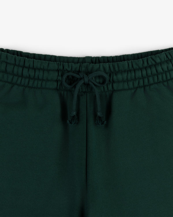 Close-up of the elastic waistband and drawstring bow on Crest Sweatpants in dark green.
