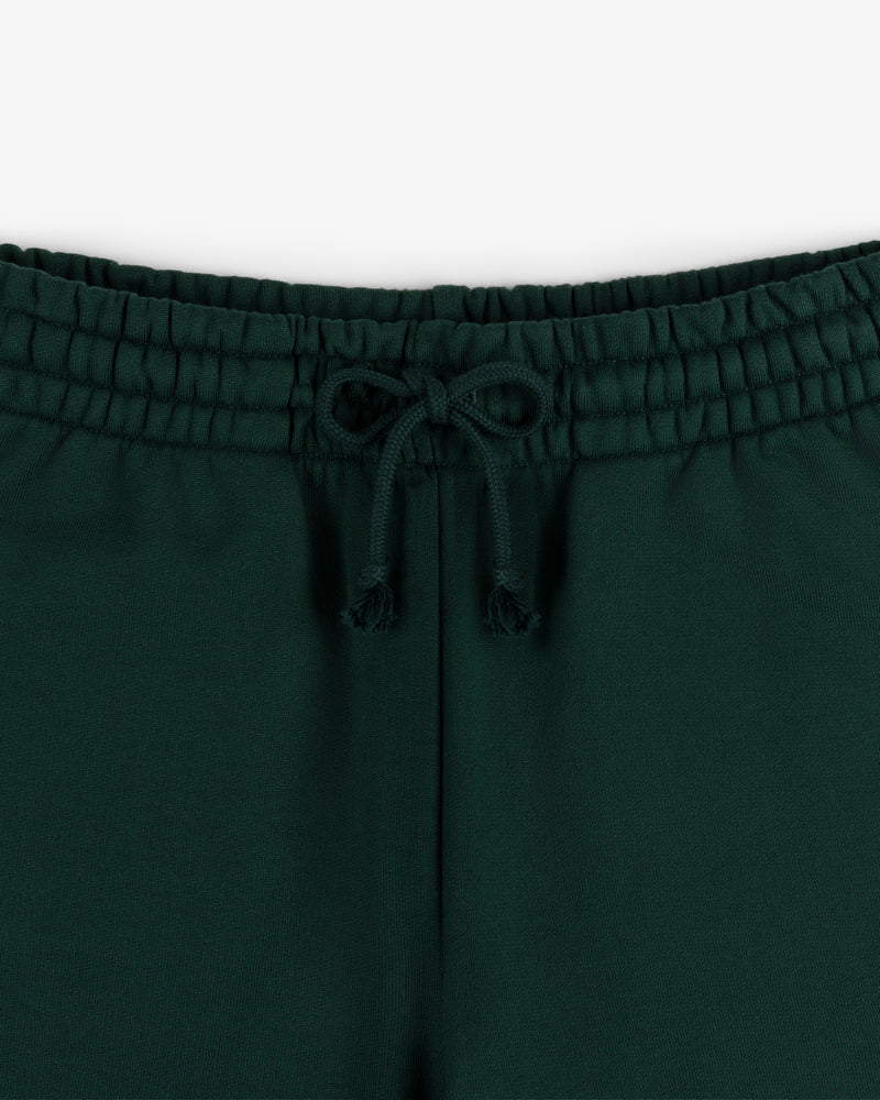 Close-up of the elastic waistband and drawstring bow on Crest Sweatpants in dark green.