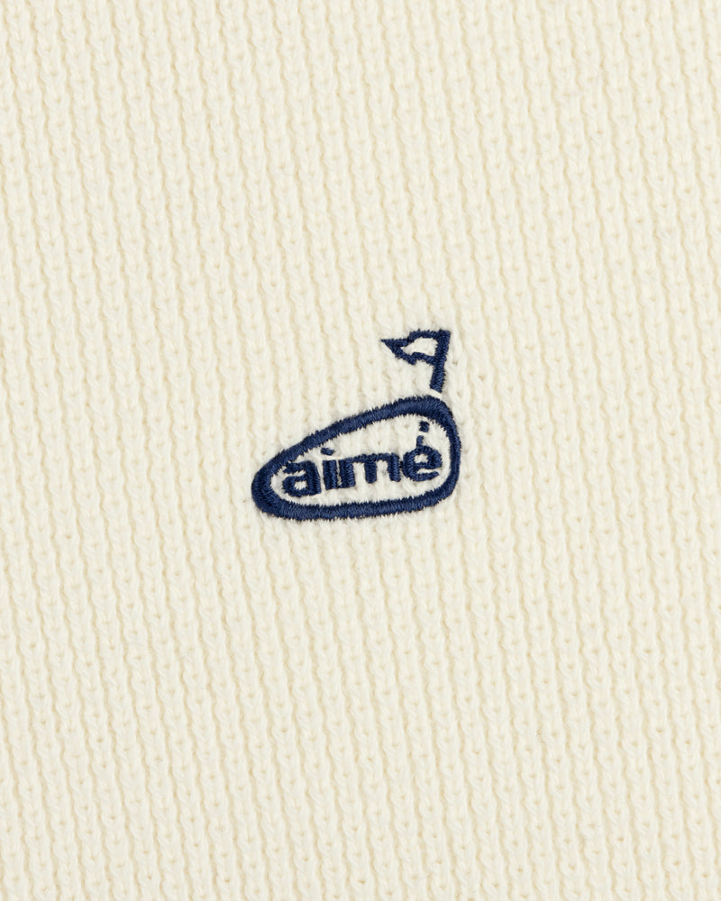 The ALD Golf Piqué Full Zip Sweater features white ribbed fabric and a small blue embroidered aimé logo with an arrow above the "e".
