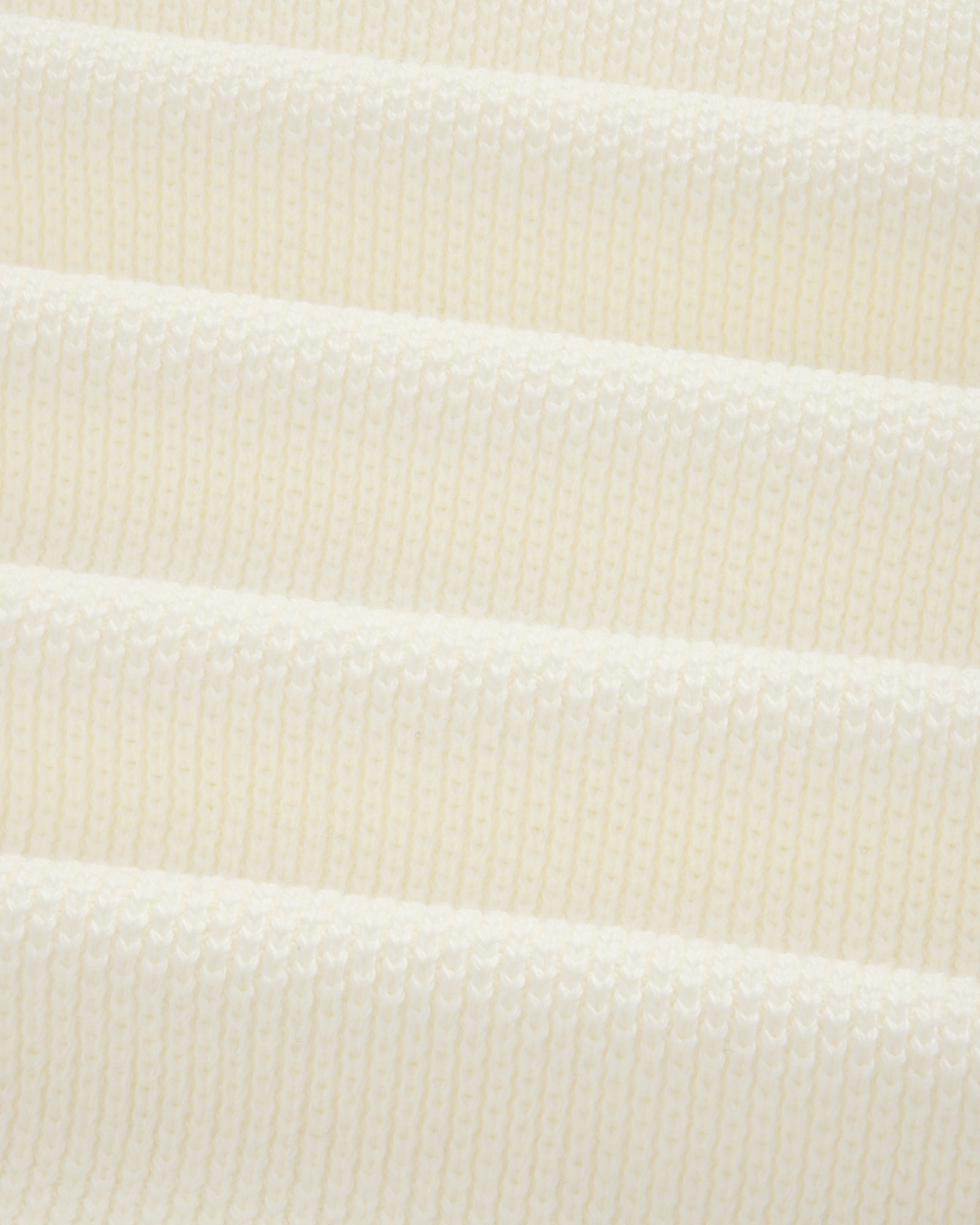 Close-up of ALD Golf Piqué Full Zip Sweater’s white ribbed knit with evenly spaced horizontal ridges.