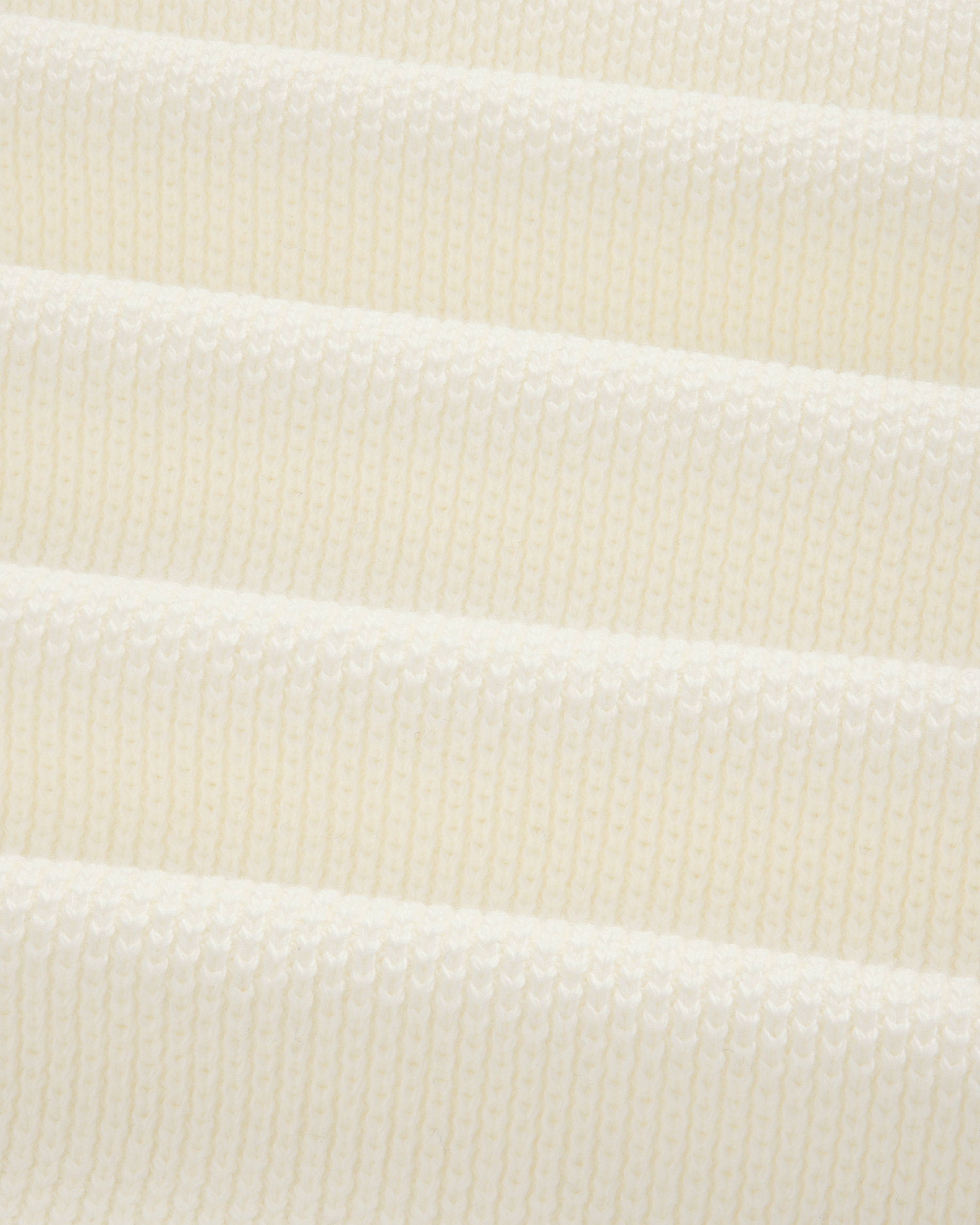 Close-up of ALD Golf Piqué Full Zip Sweater’s white ribbed knit with evenly spaced horizontal ridges.