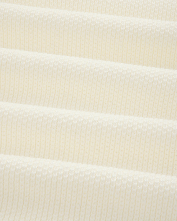 Close-up of ALD Golf Piqué Full Zip Sweater’s white ribbed knit with evenly spaced horizontal ridges.