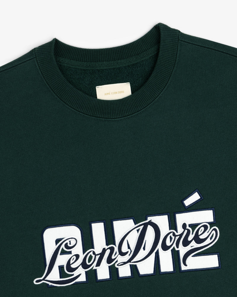 Dark green Overlay Logo Crewneck Sweatshirt with Aimé Leon Dore embroidered in white and navy on the front.