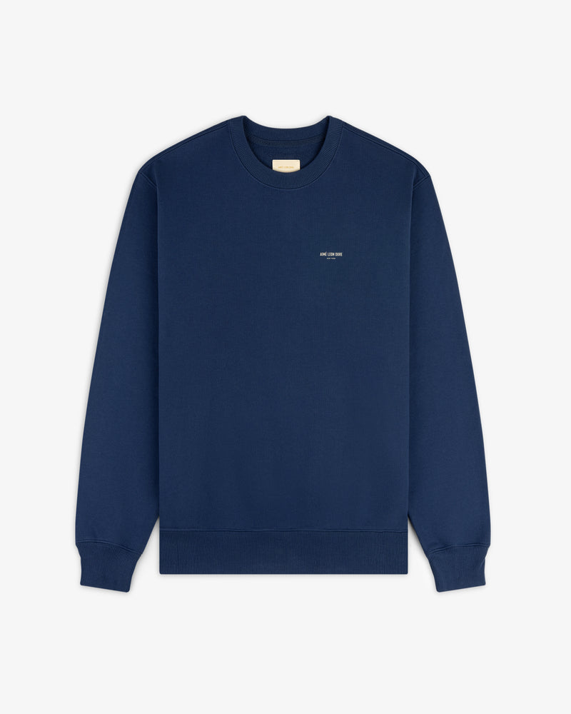 The Safari Crewneck Sweatshirt is a plain navy blue crewneck with small white text, shown laid flat on a white background.