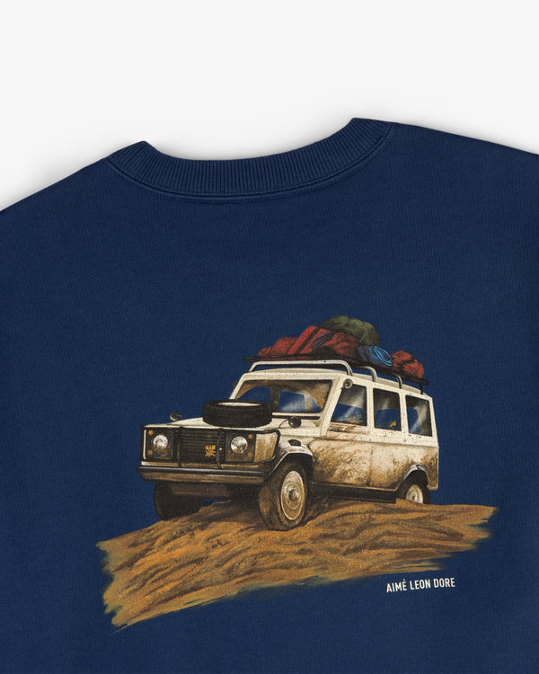 Safari Crewneck Sweatshirt in navy featuring a graphic loaded off-road vehicle and Aimé Leon Dore text underneath.
