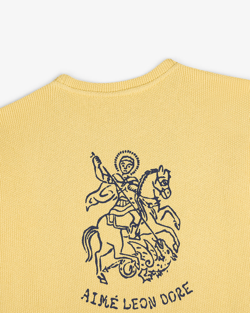 Yellow knit Saint George Piqué Crewneck Sweatshirt with dark blue line art and Aimé Leon Dore text below.