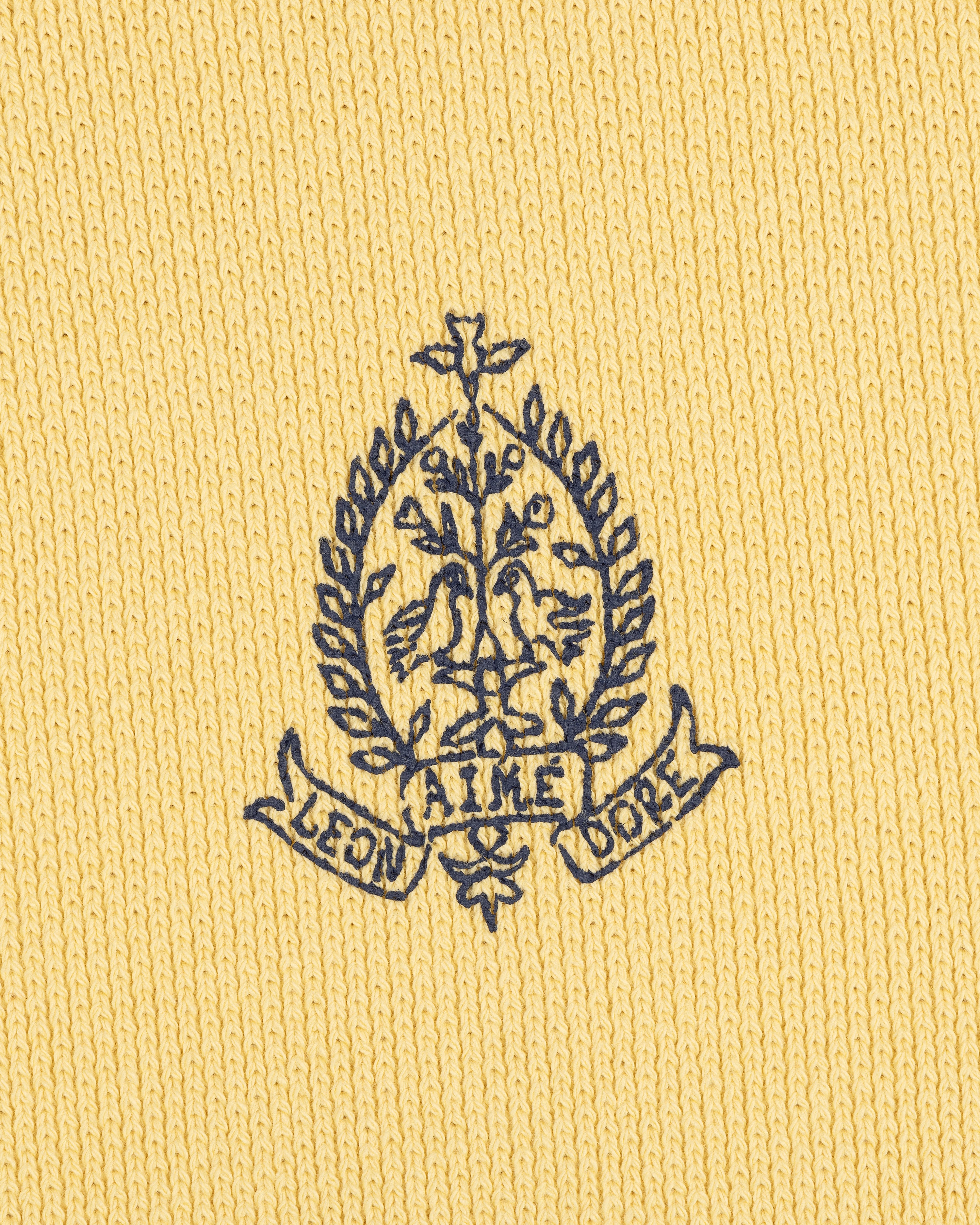 Navy embroidered crest with two birds and AIME LEON DORE on yellow Saint George Piqué Crewneck Sweatshirt.