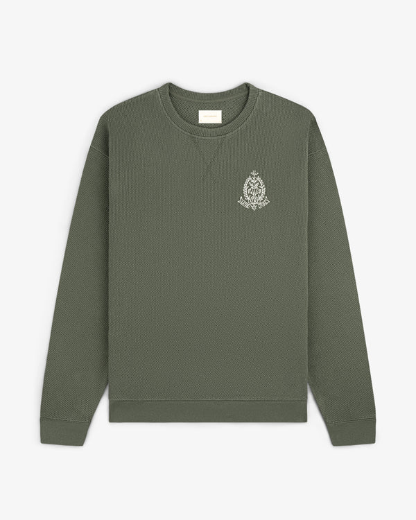 Olive green Saint George Piqué Crewneck Sweatshirt with small white logo on left chest, shown flat on white background.