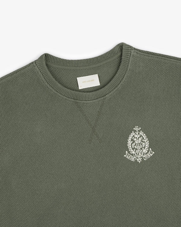 Saint George Piqué Crewneck Sweatshirt in olive green with a white embroidered crest on the left chest.