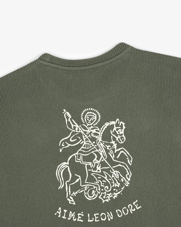 Olive green Saint George Piqué Crewneck Sweatshirt with white knight and dragon graphic and AIMÉ LEON DORE text below.