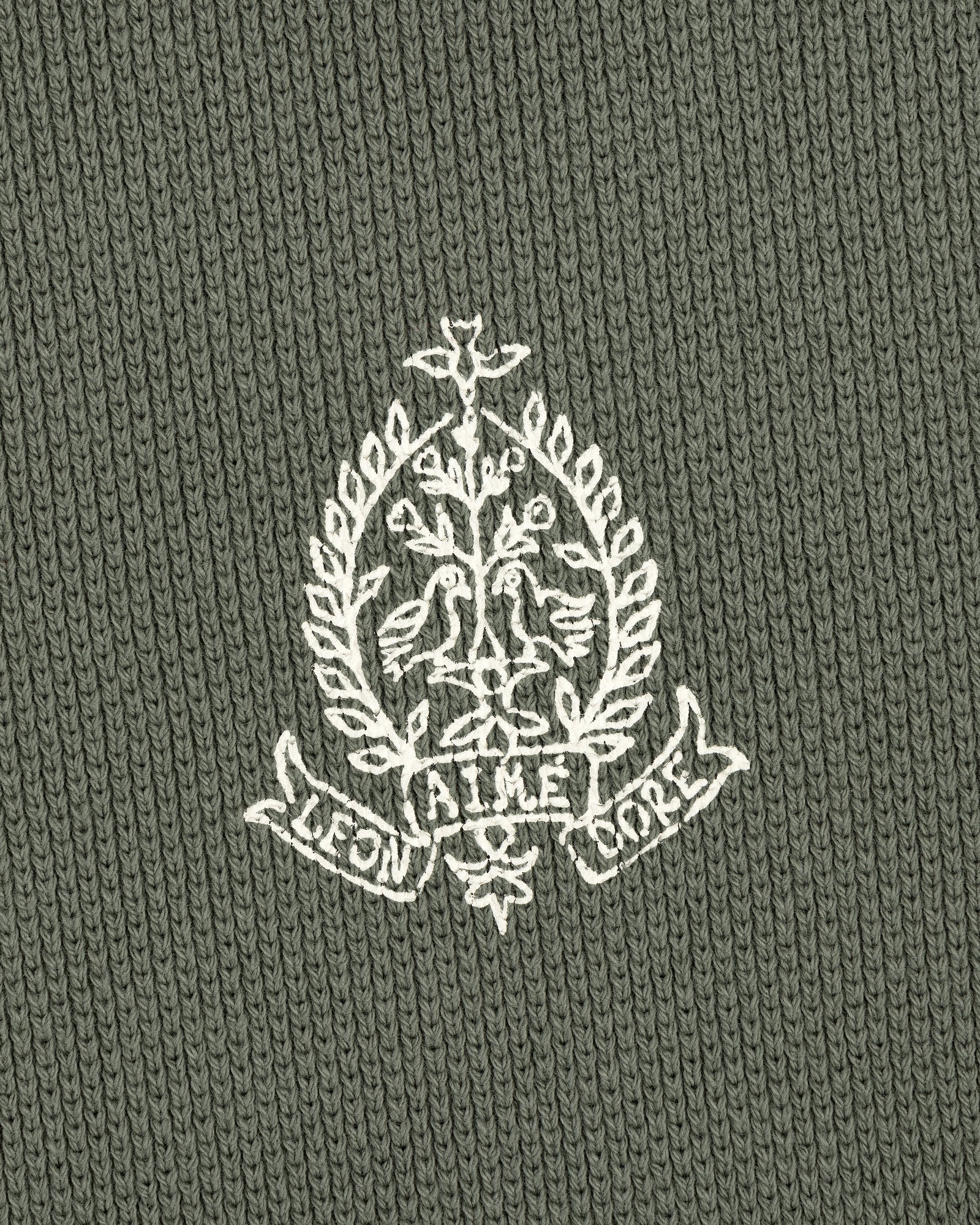 Embroidered white crest with birds, leaves, and AIME LEON DORE text on olive Saint George Piqué Crewneck Sweatshirt.