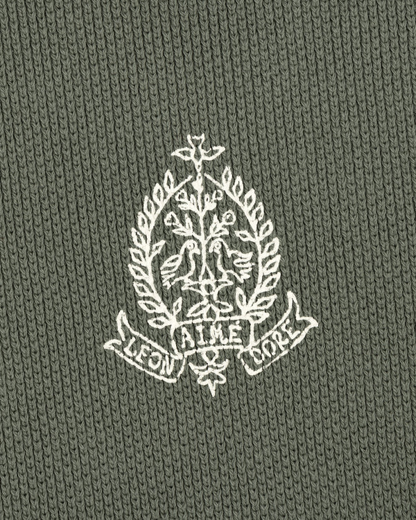 Embroidered white crest with birds, leaves, and AIME LEON DORE text on olive Saint George Piqué Crewneck Sweatshirt.