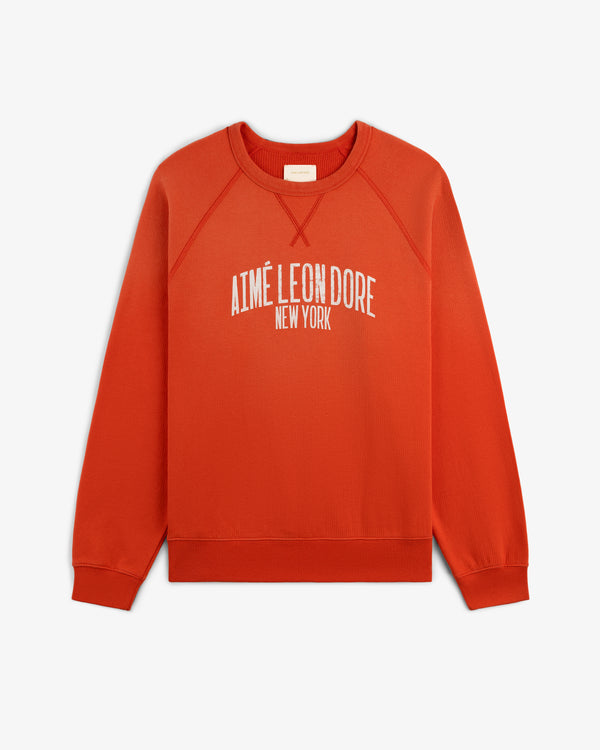 A red Vintage Washed Crewneck Sweatshirt with AIMÉ LEON DORE NEW YORK printed in white on the front.