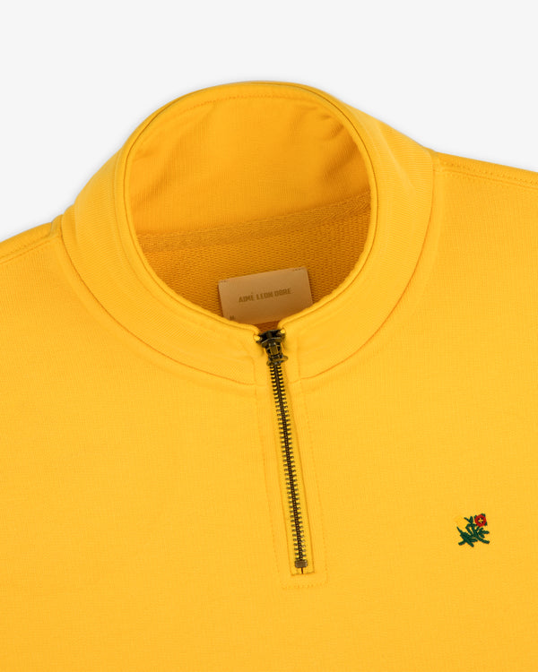 Sun Faded Crest Quarter Zip: Yellow pullover with standing collar, green and red embroidered logo on the chest.
