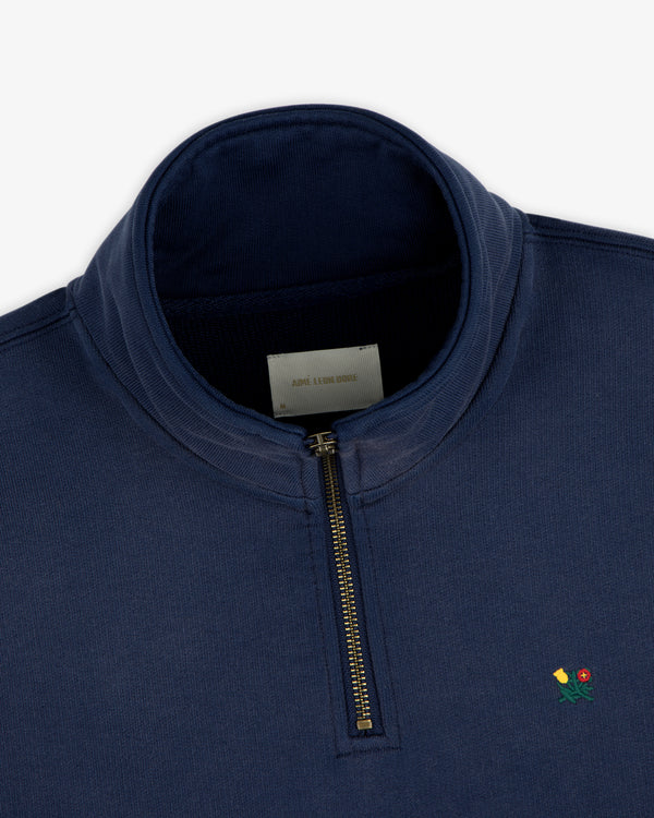Sun Faded Crest Quarter Zip in navy blue with a metal zipper and small embroidered rose on the chest.