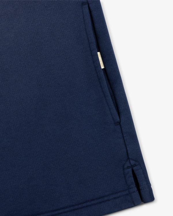 Close-up of the Sun Faded Crest Quarter Zip in navy blue, showing a pocket and small fabric tag on a white background.