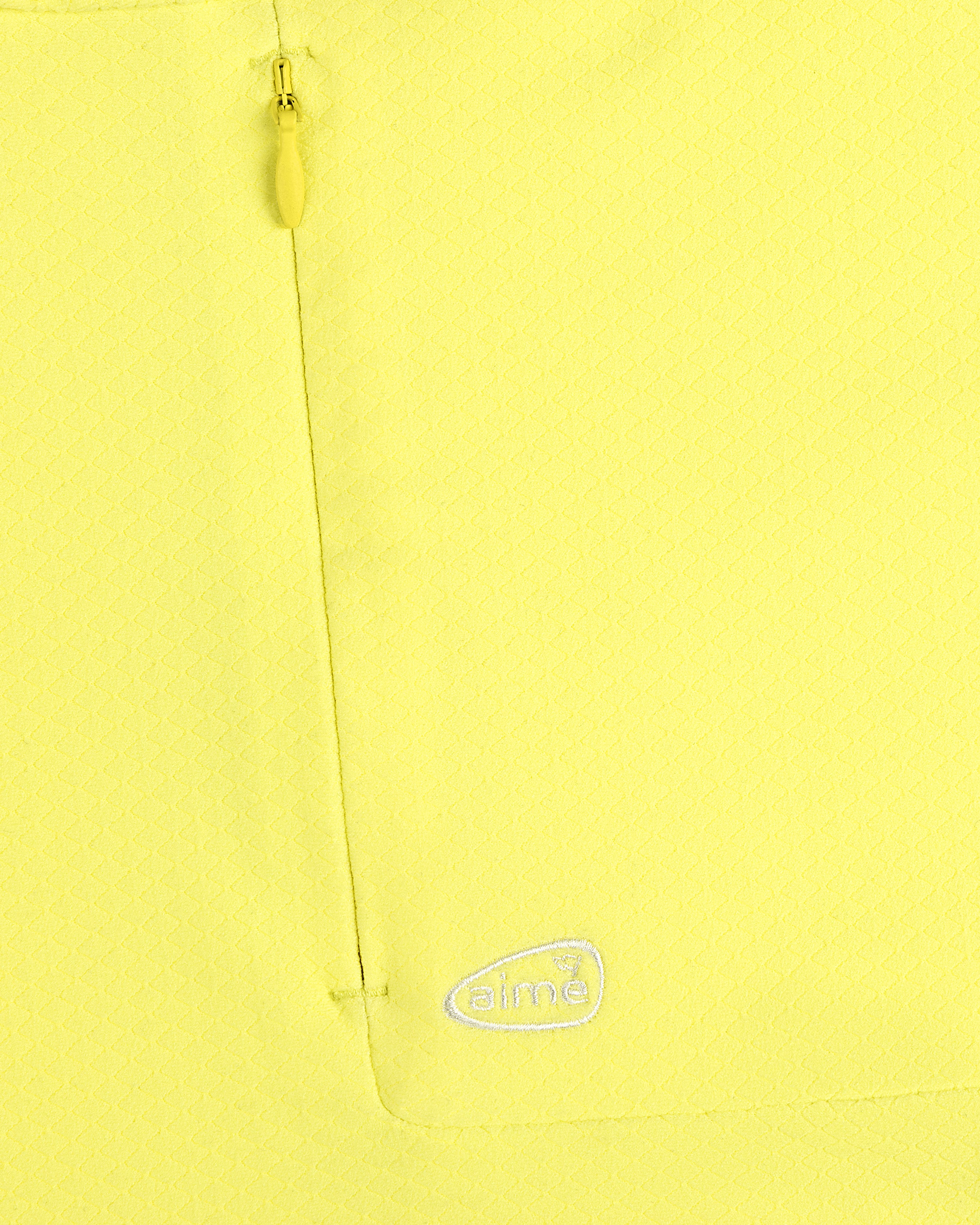 Close-up of ALD Golf Quarter Zip Pullover in yellow with textured fabric, zip pocket, and embroidered white aimé logo.