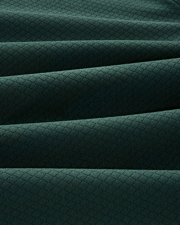 The ALD Golf Quarter Zip Pullover features dark green fabric with a subtle diamond pattern and soft horizontal pleats.