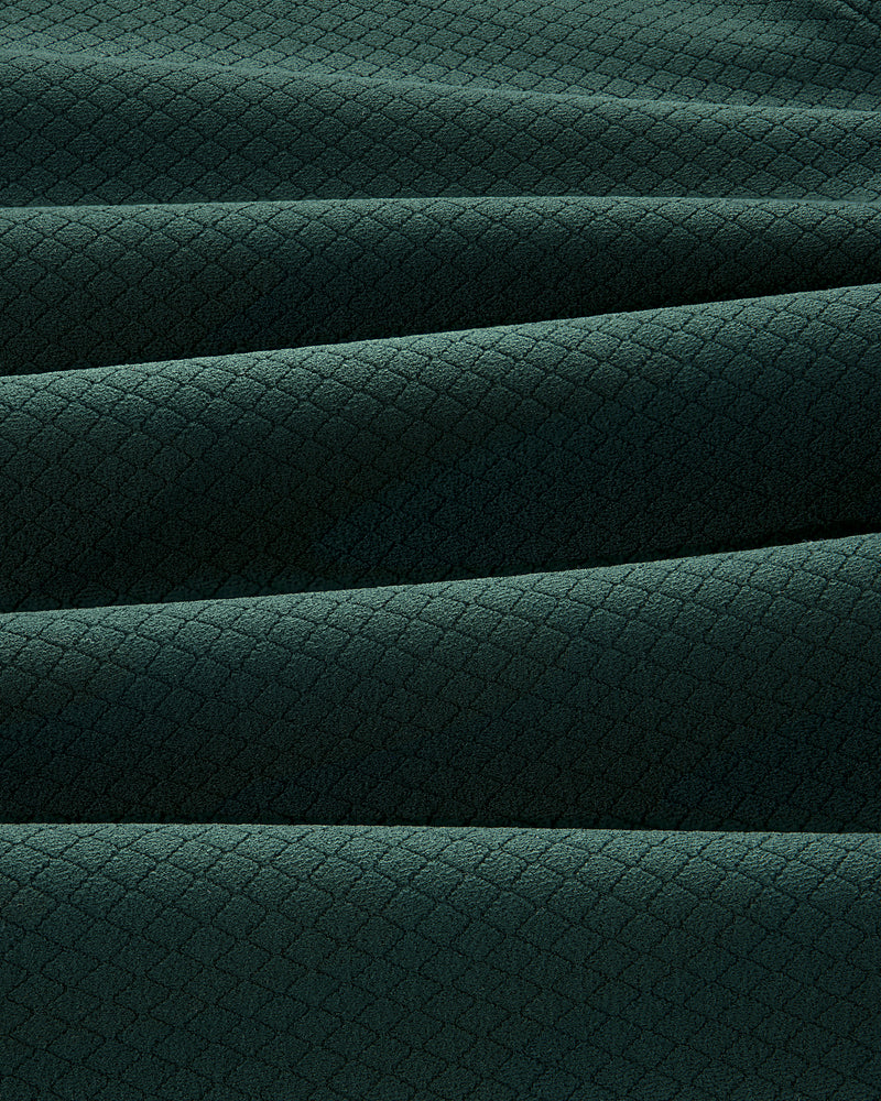 The ALD Golf Quarter Zip Pullover features dark green fabric with a subtle diamond pattern and soft horizontal pleats.
