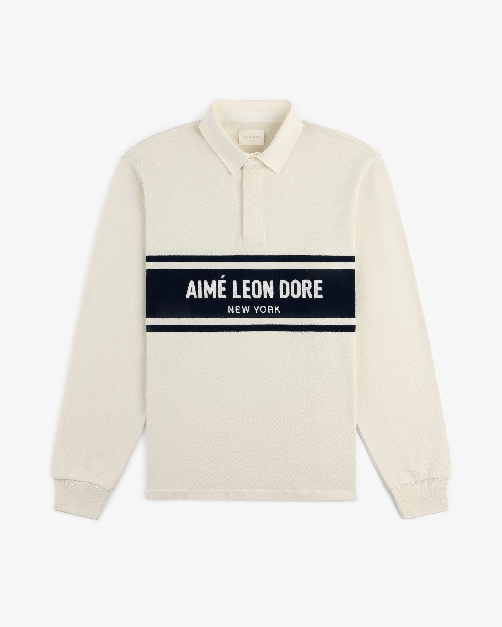 Chest Stripe Logo Rugby: cream long-sleeve polo with black stripe and AIMÉ LEON DORE NEW YORK across chest.