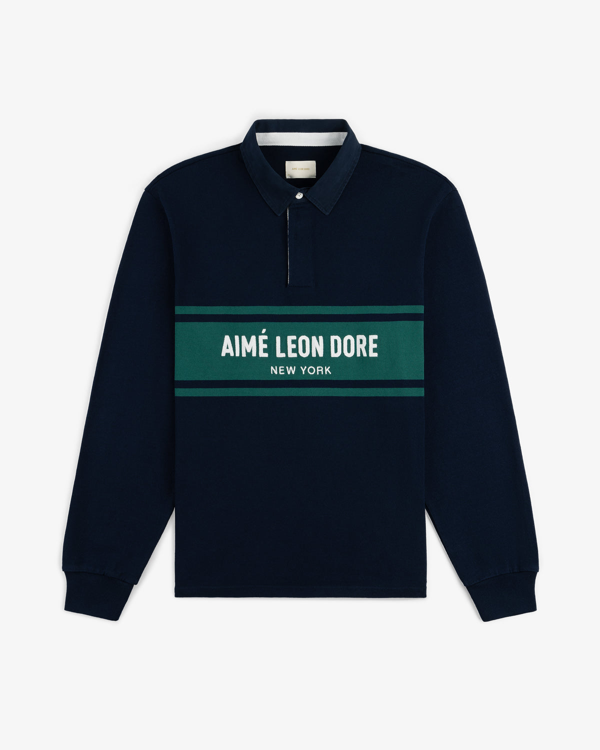 Chest Stripe Logo Rugby in navy with green and white stripes and “AIMÉ LEON DORE NEW YORK” across the chest.