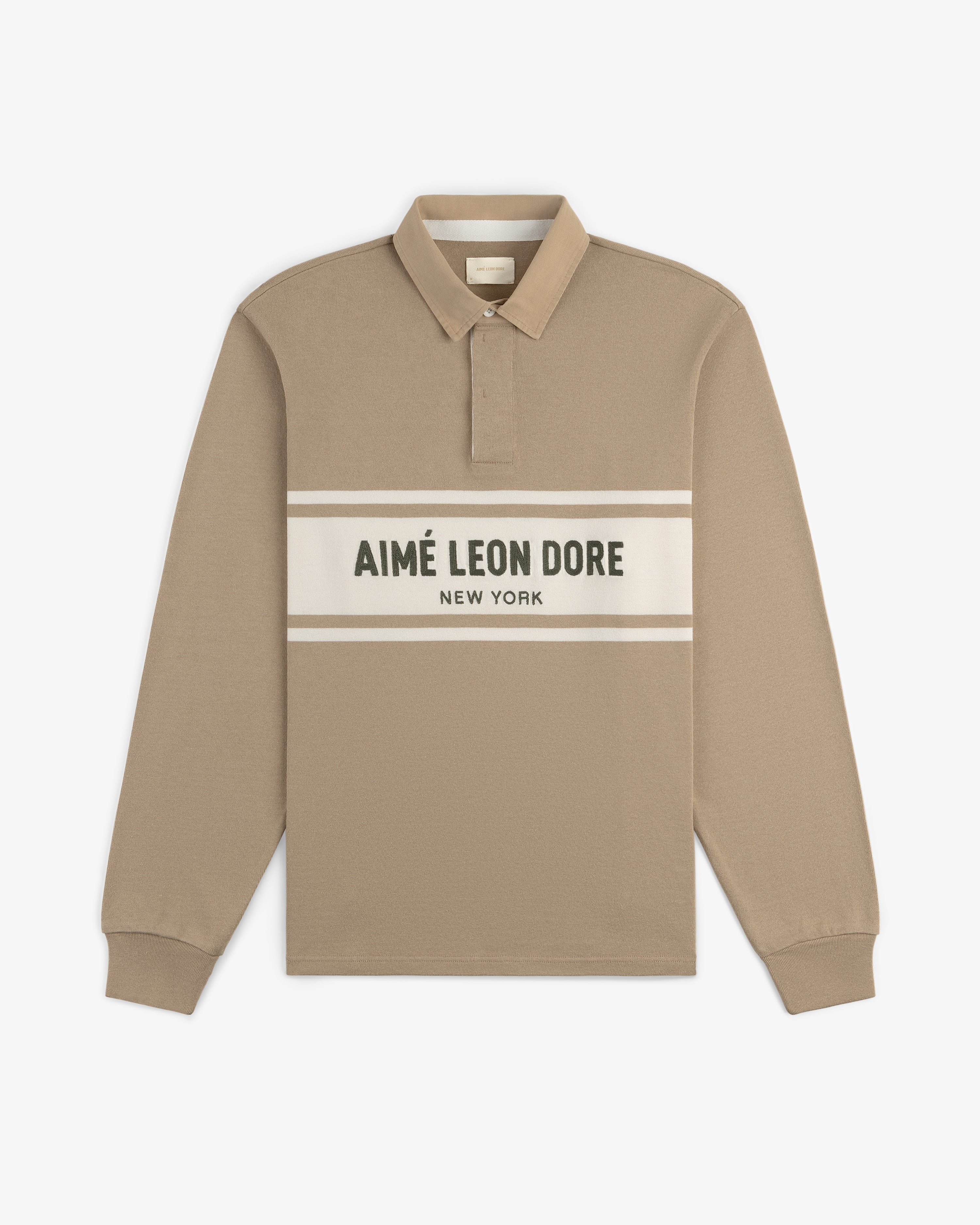Beige Chest Stripe Logo Rugby with AIMÉ LEON DORE NEW YORK logo on a white stripe across the chest.