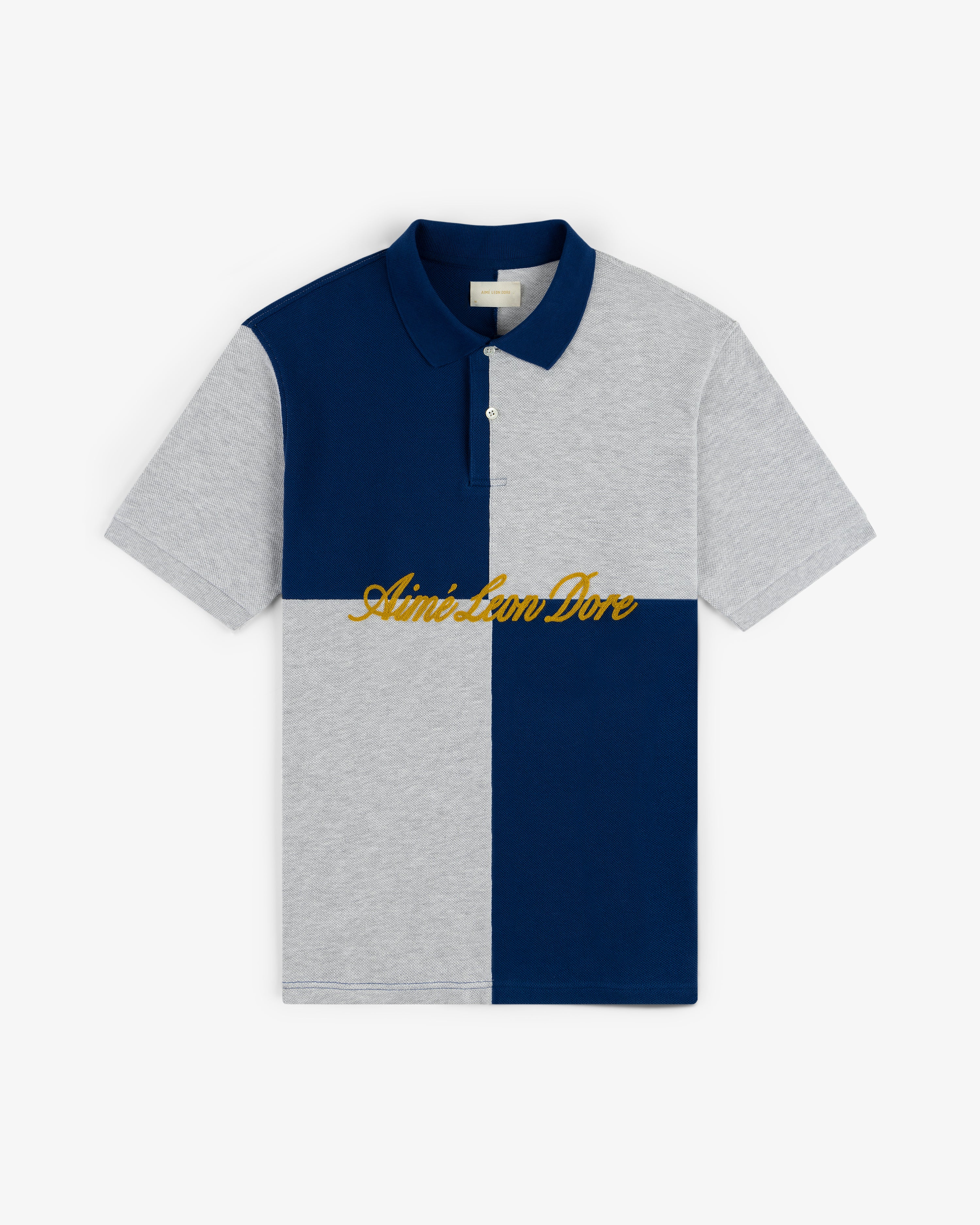Color Blocked Pique Polo with navy and gray panels, gold Aimé Leon Dore chest embroidery, short sleeves.