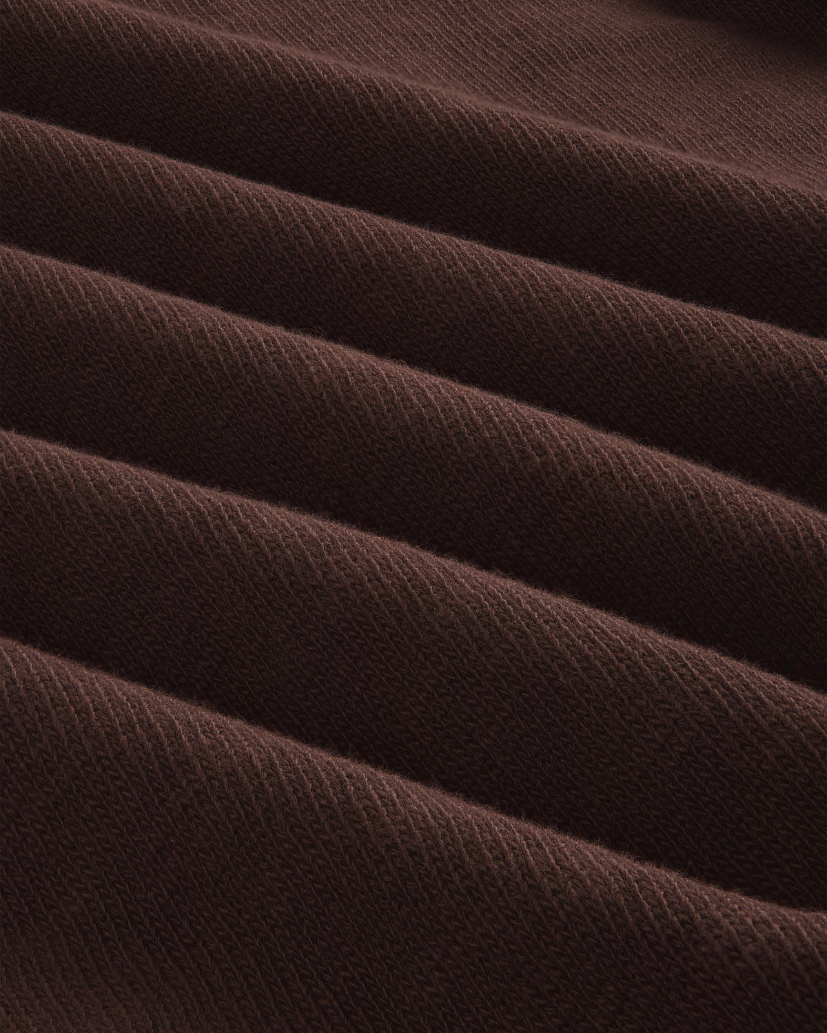 Close-up of Long-Sleeve Slub Football Tee in dark brown, showing ribbed fabric with diagonal texture and repeating ridges.
