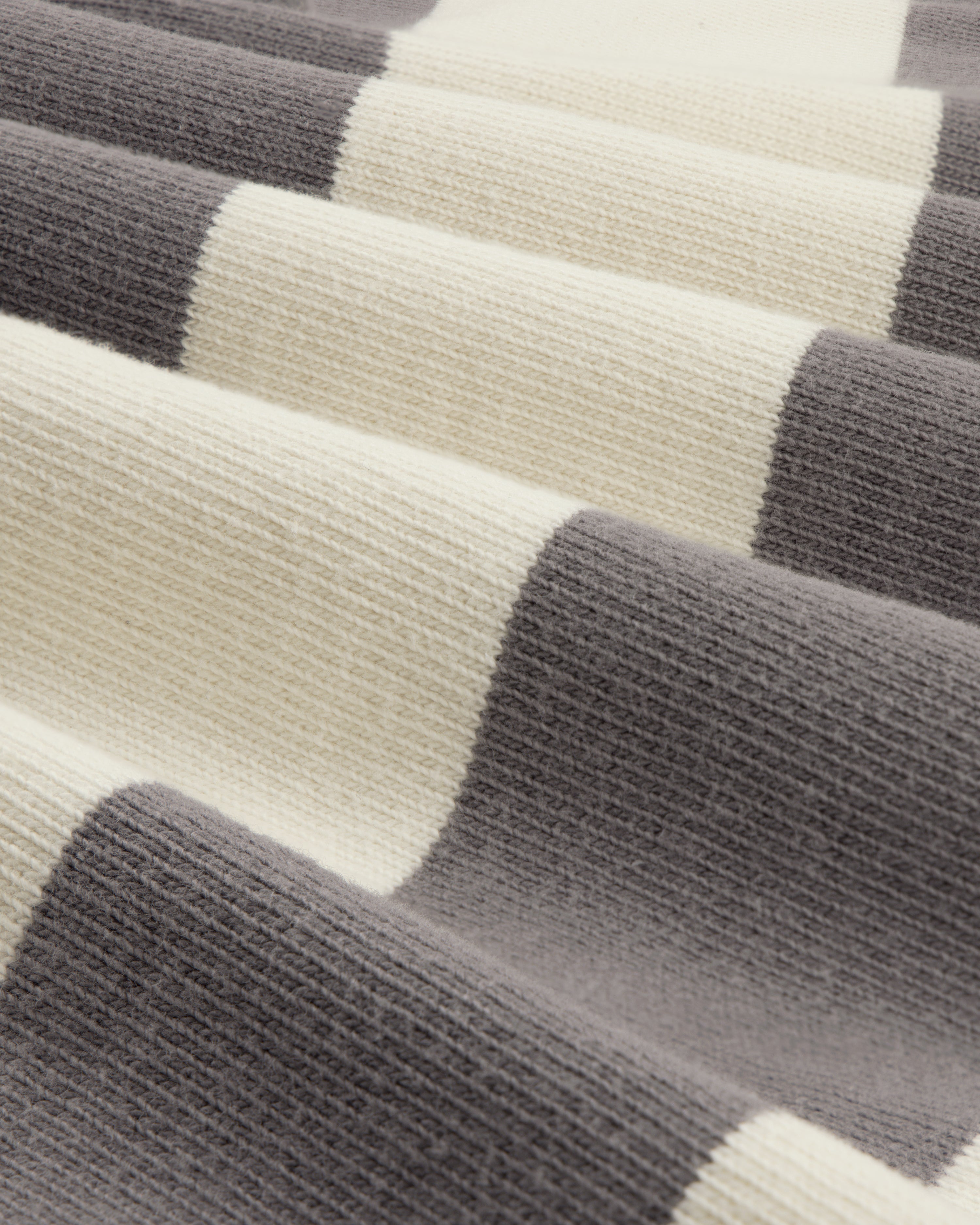 Close-up of the Striped Crest Rugby fabric featuring wide cream and gray horizontal stripes.