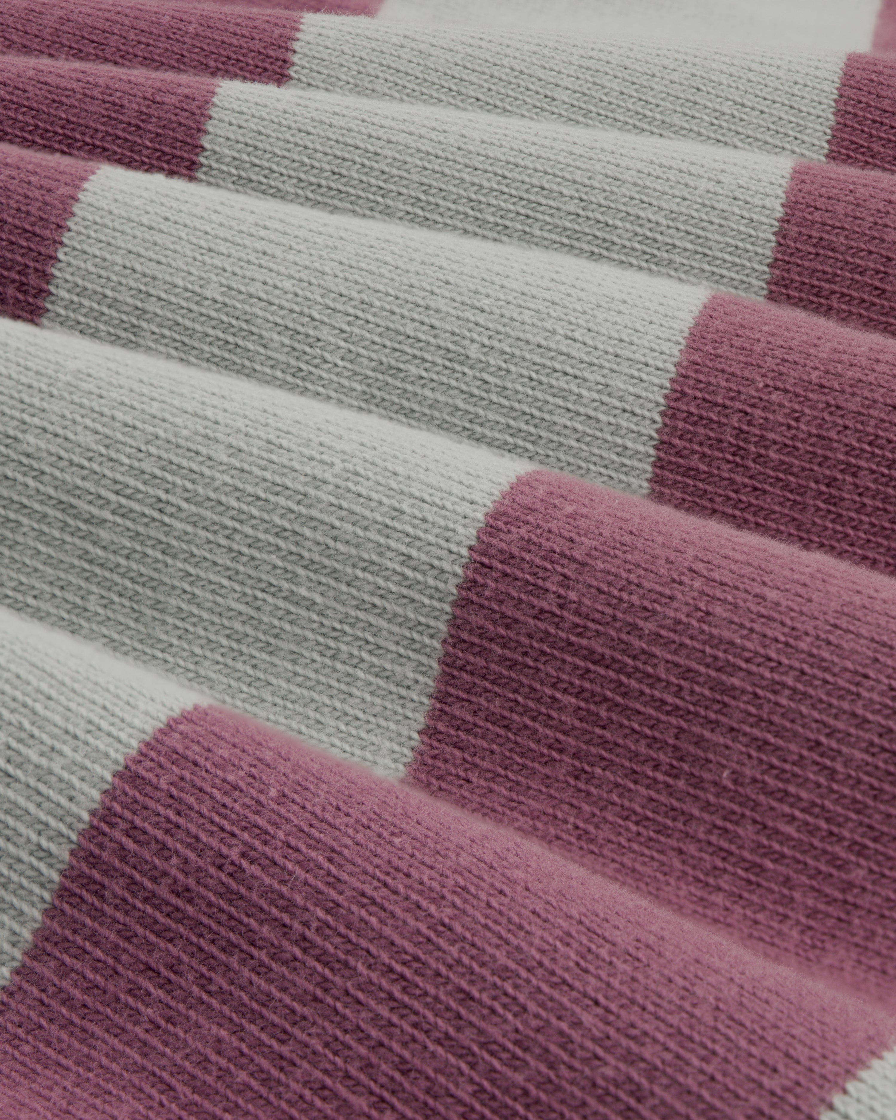 Close-up of the Striped Crest Rugby, featuring wide alternating light gray and mauve knitted stripes.