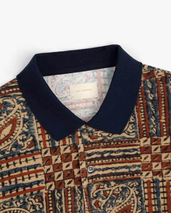 Paisley Printed Piqué Polo with a navy collar and red, blue, and beige geometric patterns.
