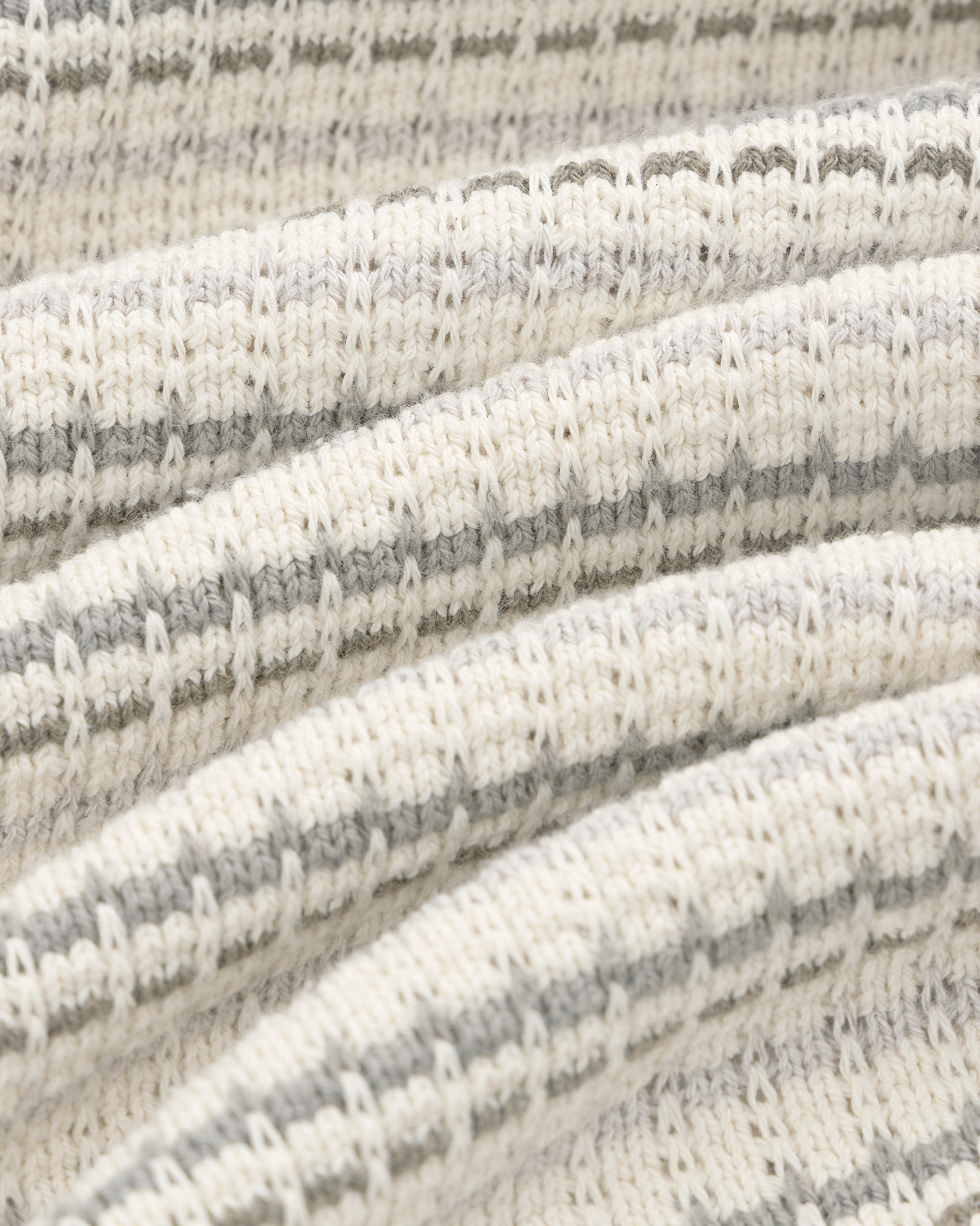 Close-up of the Jacquard Striped Tee's cream and grey ribbed knit fabric with horizontal stripes and a cozy texture.