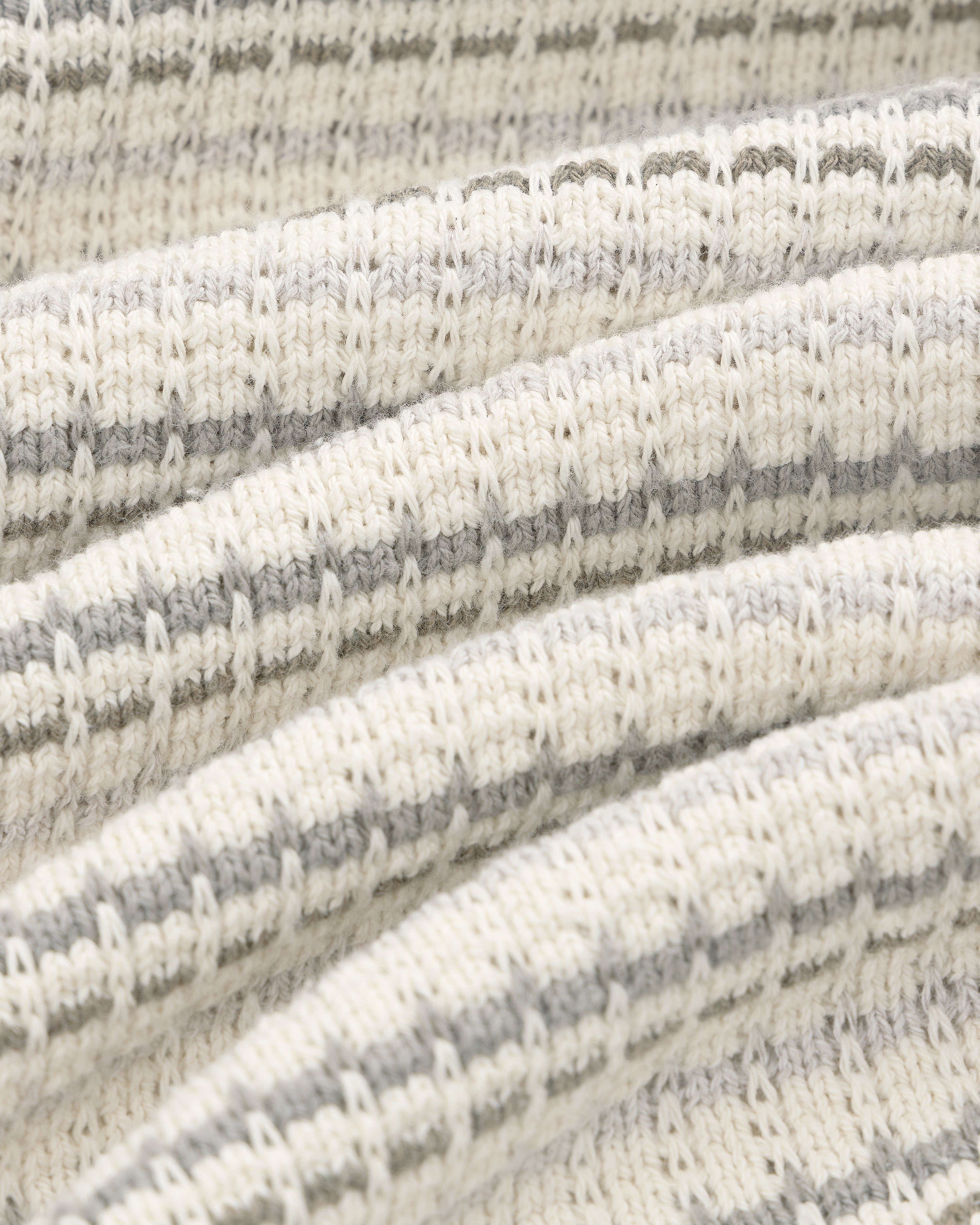 Close-up of the Jacquard Striped Tee's cream and grey ribbed knit fabric with horizontal stripes and a cozy texture.