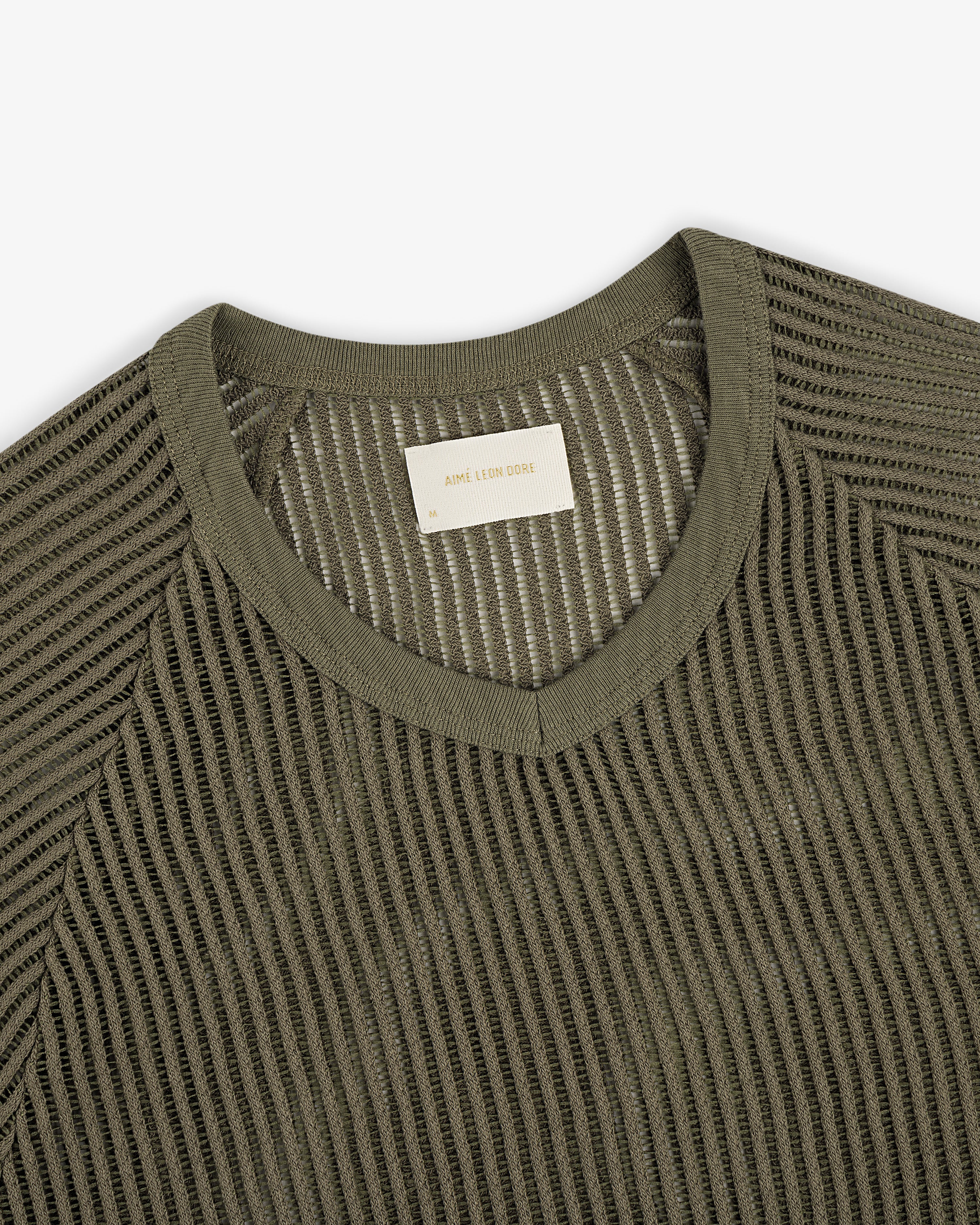 Olive green mesh V-neck tee featuring a visible woven label inside the collar.