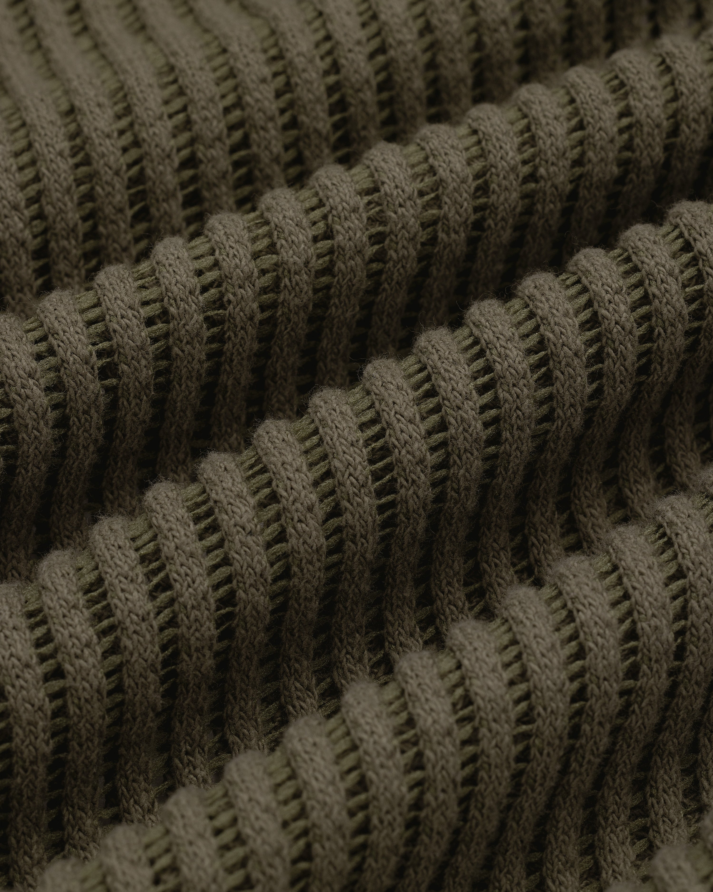 Close-up of olive green ribbed knit on the Mesh V-Neck Tee, showing horizontal ridges and textured detail.