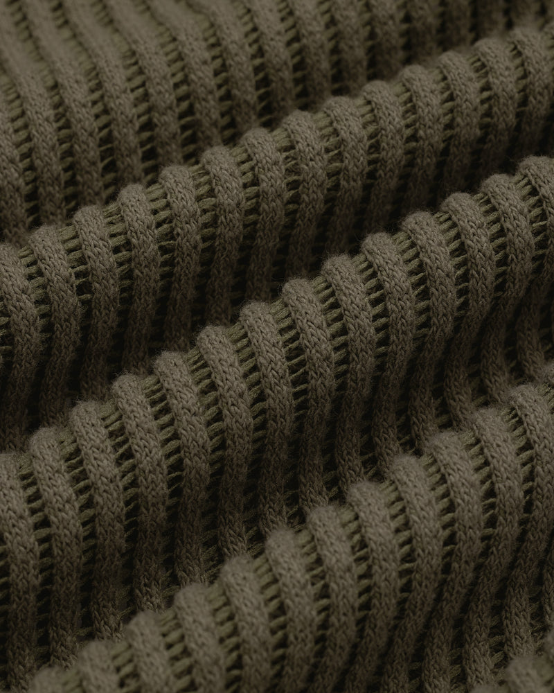 Close-up of olive green ribbed knit on the Mesh V-Neck Tee, showing horizontal ridges and textured detail.