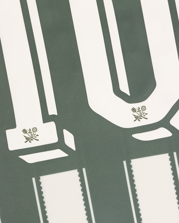 Aimé Cup Soccer Jersey features white block numbers with small flowers on green and vertical white stripes.
