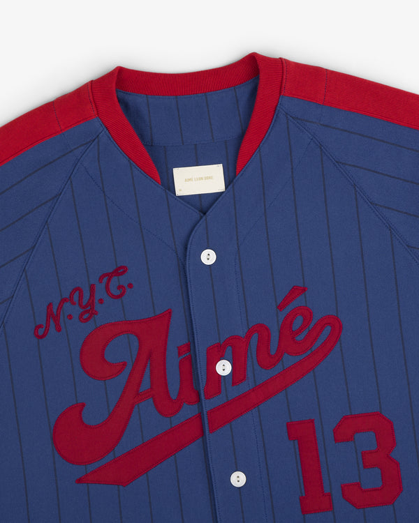 Aimé Baseball Jersey in blue and red pinstripes with N.Y.C. Aimé and the number 13 on the front.