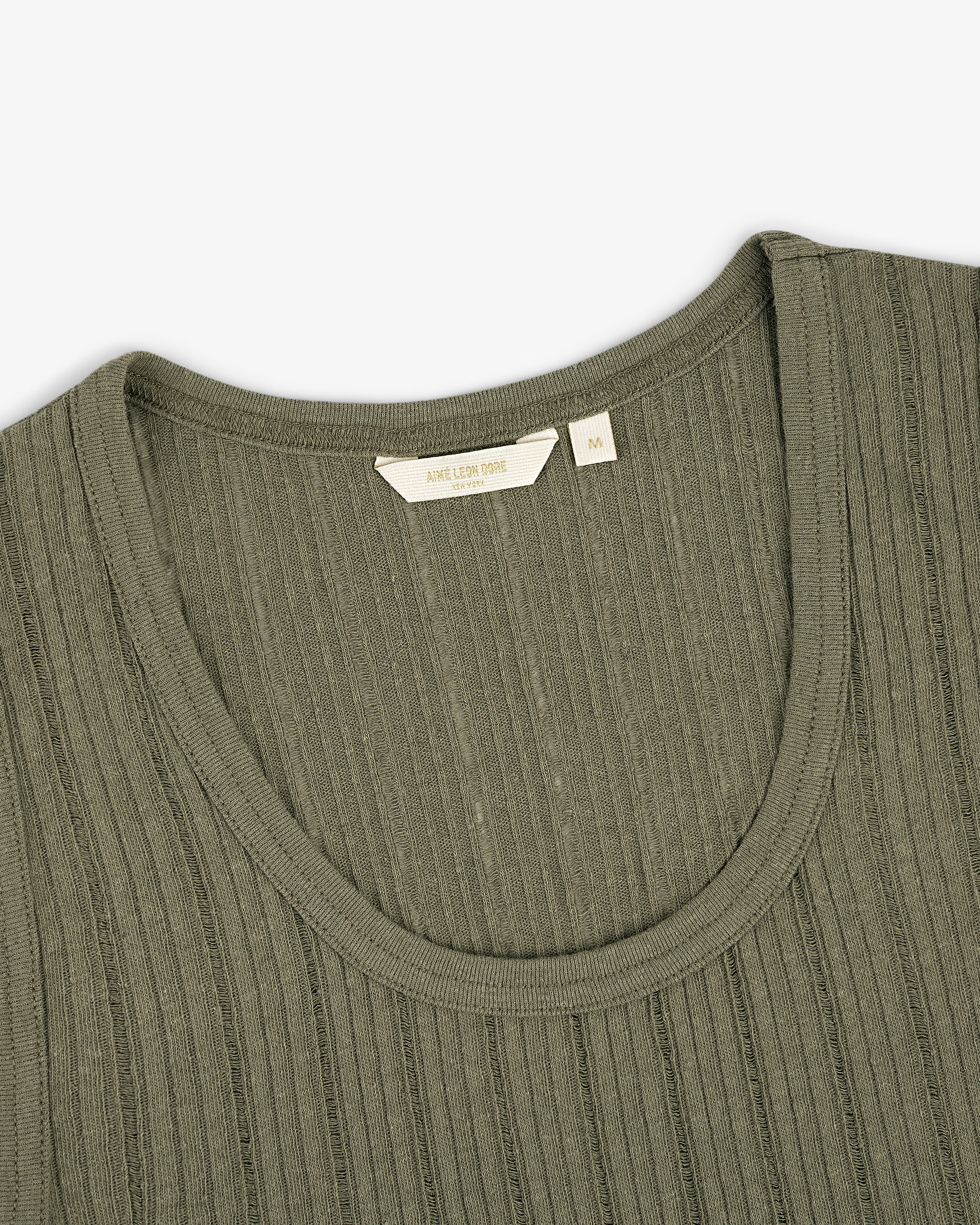 Close-up of the Drop Needle Tank Top in olive green with ribbed knit, round neckline, and visible size tag.