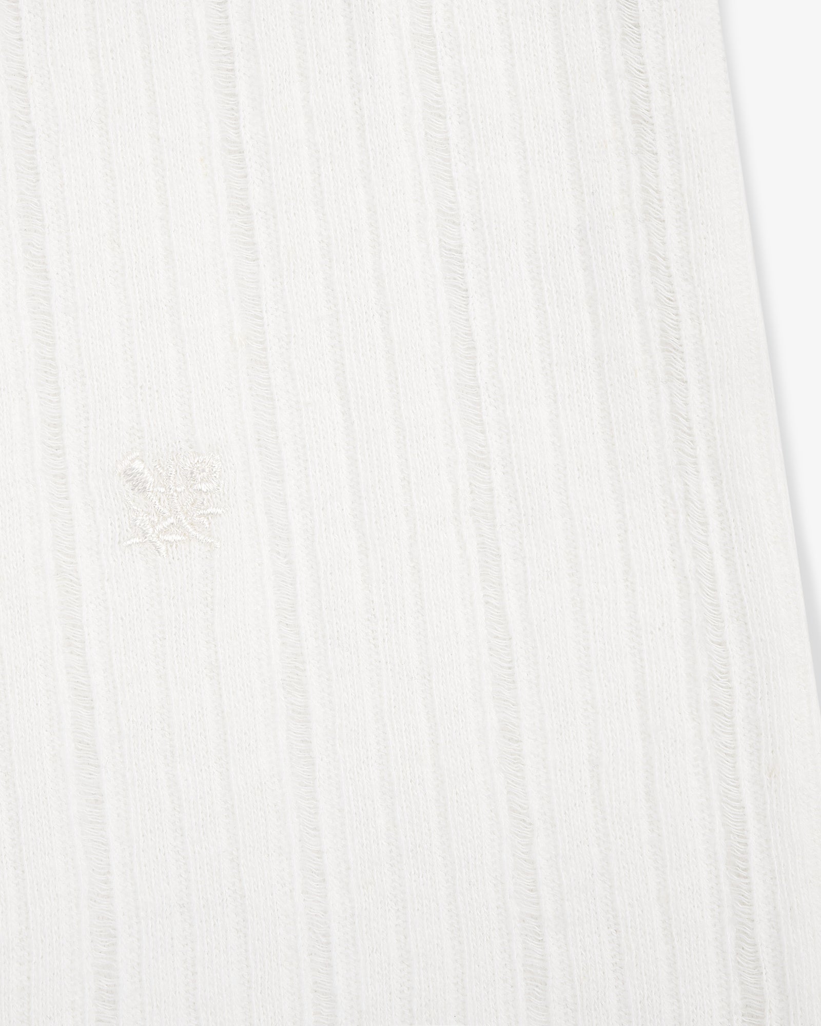 Close-up of the Drop Needle Tank Top's white ribbed fabric with subtle vertical stripes and a central embroidered emblem.