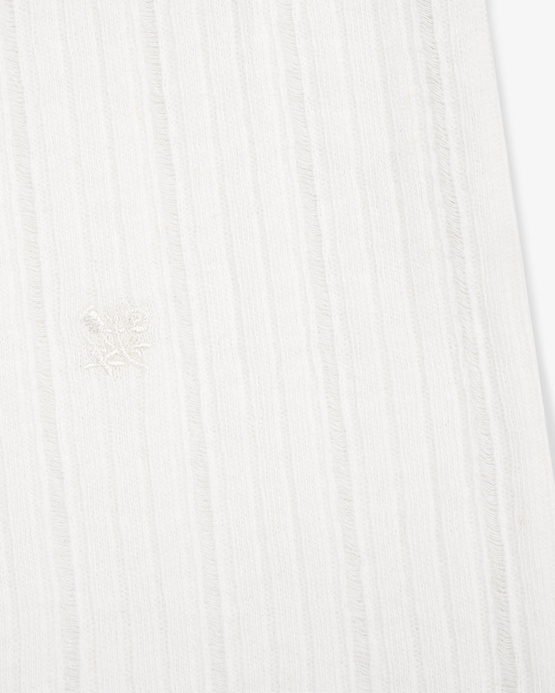 Close-up of the Drop Needle Tank Top's white ribbed fabric with subtle vertical stripes and a central embroidered emblem.