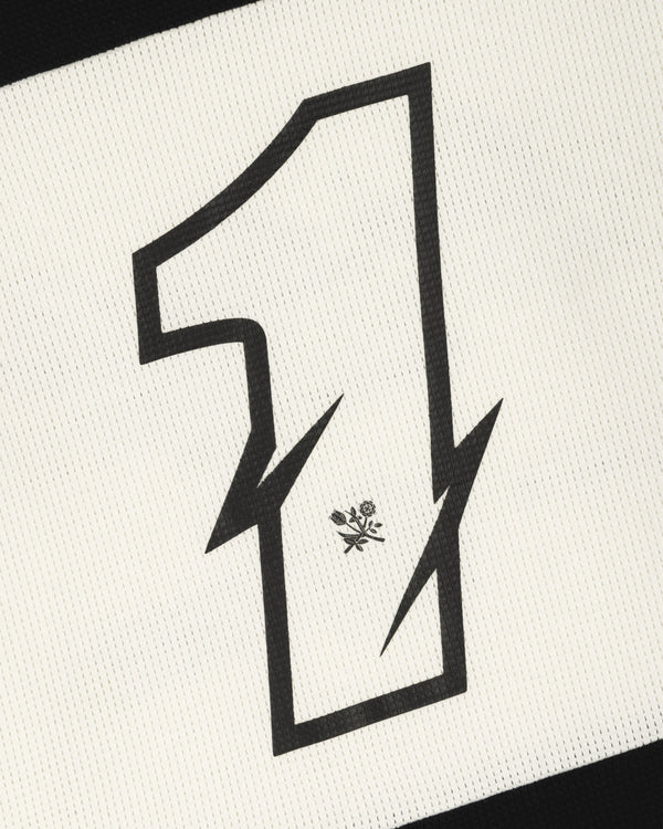 A bold, black number 1 with zigzag edges and a flower sits on the Long-Sleeve Mesh Enduro Tee’s textured white fabric.