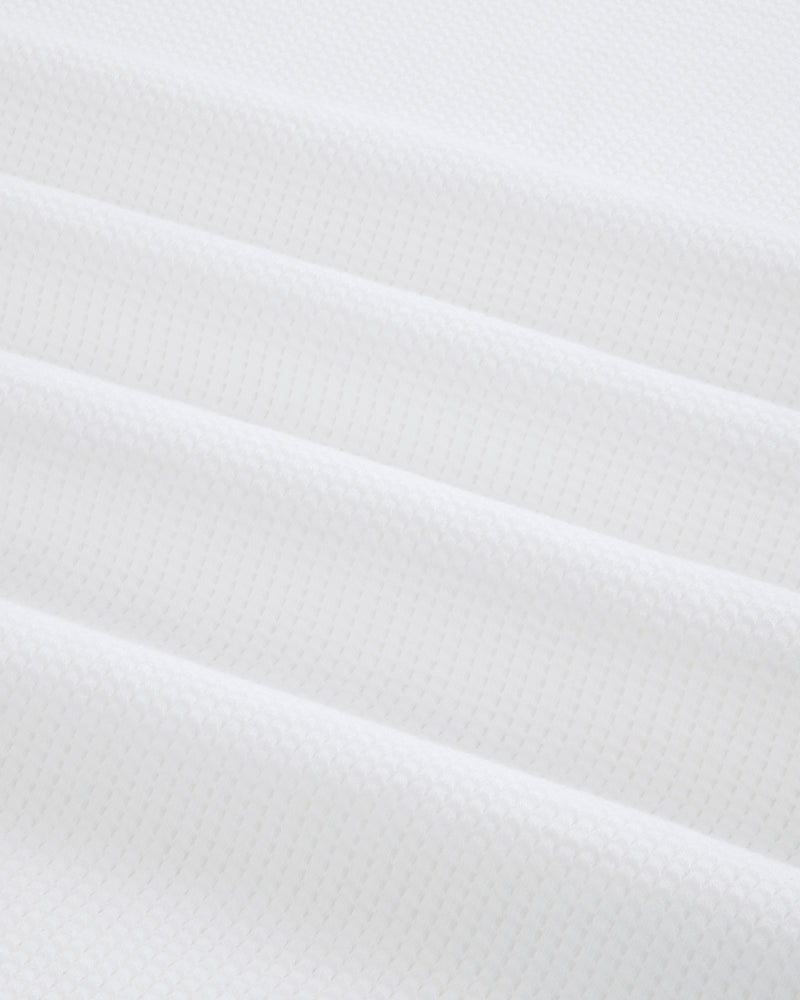 Close-up of folded white Mesh Muscle Tank fabric with a subtle geometric pattern and soft, even lighting.