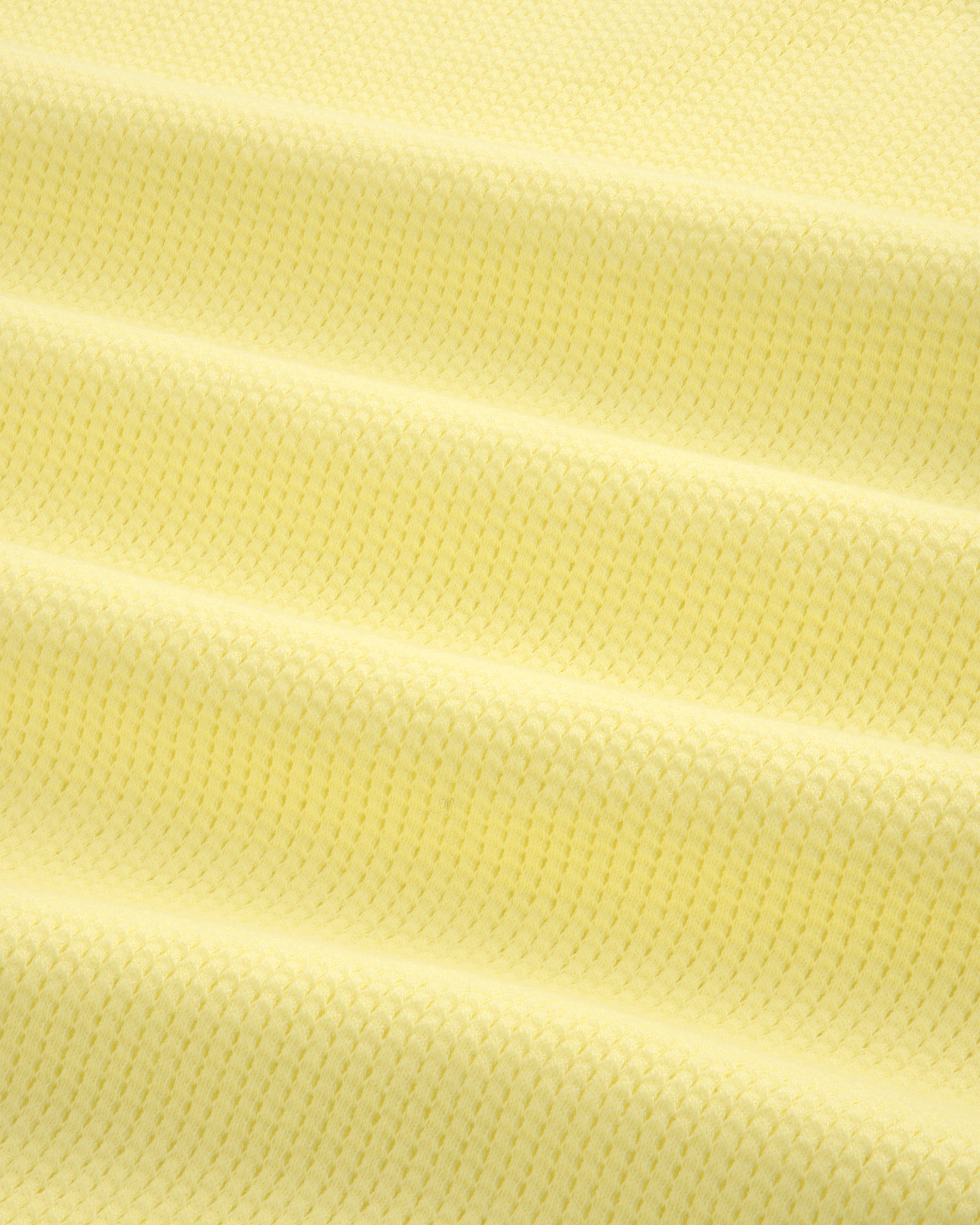 Close-up of the Mesh Muscle Tank in light yellow, showing its textured fabric and subtle horizontal folds.