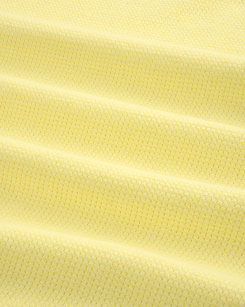 Close-up of the Mesh Muscle Tank in light yellow, showing its textured fabric and subtle horizontal folds.
