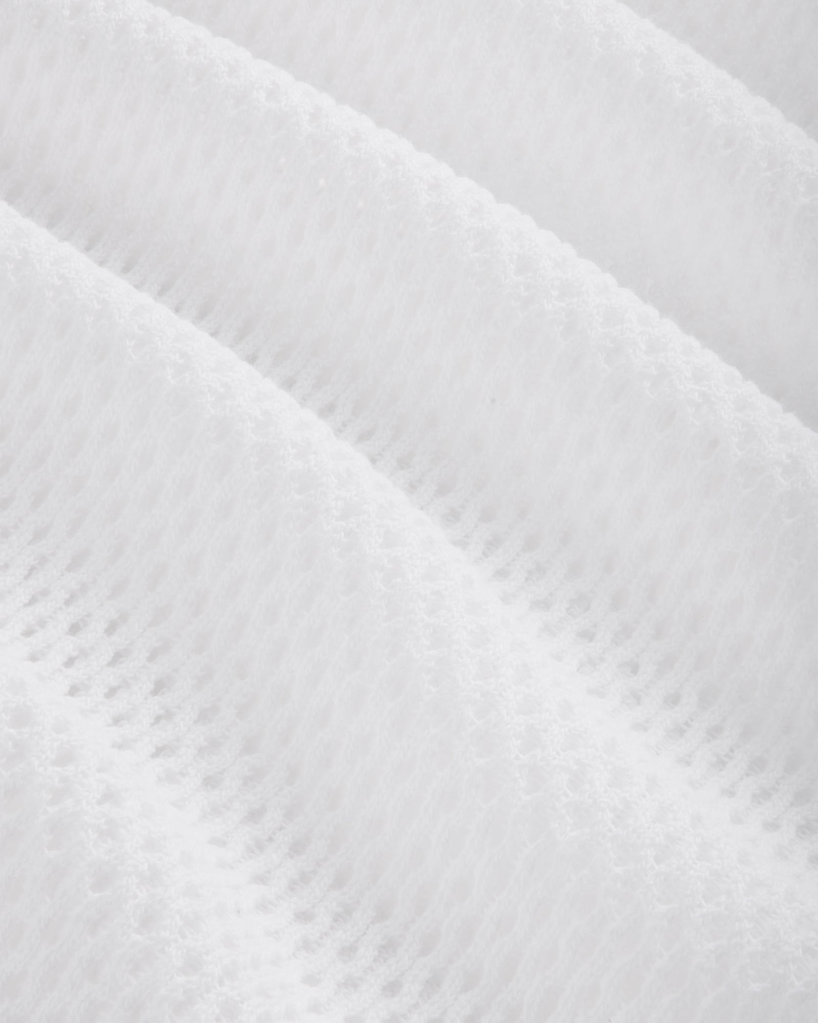 Close-up of the Mesh Tank Top's white textured fabric featuring a soft, quilted, diagonal wavy pattern.