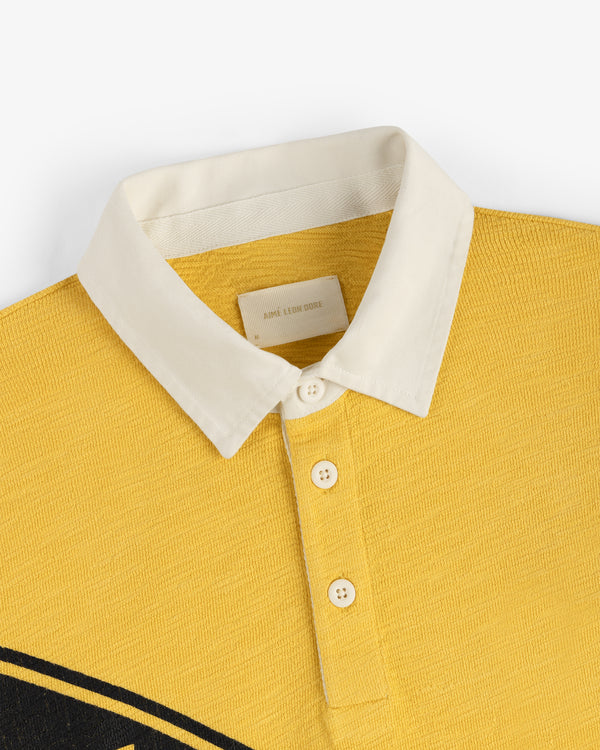 Vintage Slub Rugby polo in yellow with a white collar, three white buttons, and a visible neckline label.