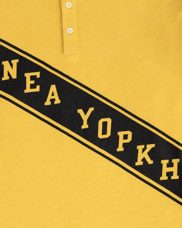 Vintage Slub Rugby in yellow with black diagonal "NEA YOPKH" text and two top buttons.