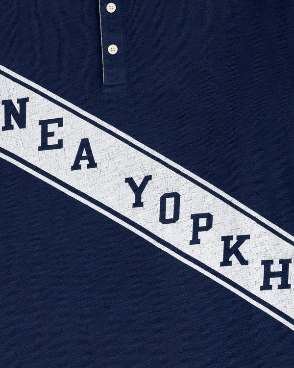 Close-up of the Vintage Slub Rugby in navy blue, featuring white diagonal text and two top buttons visible.