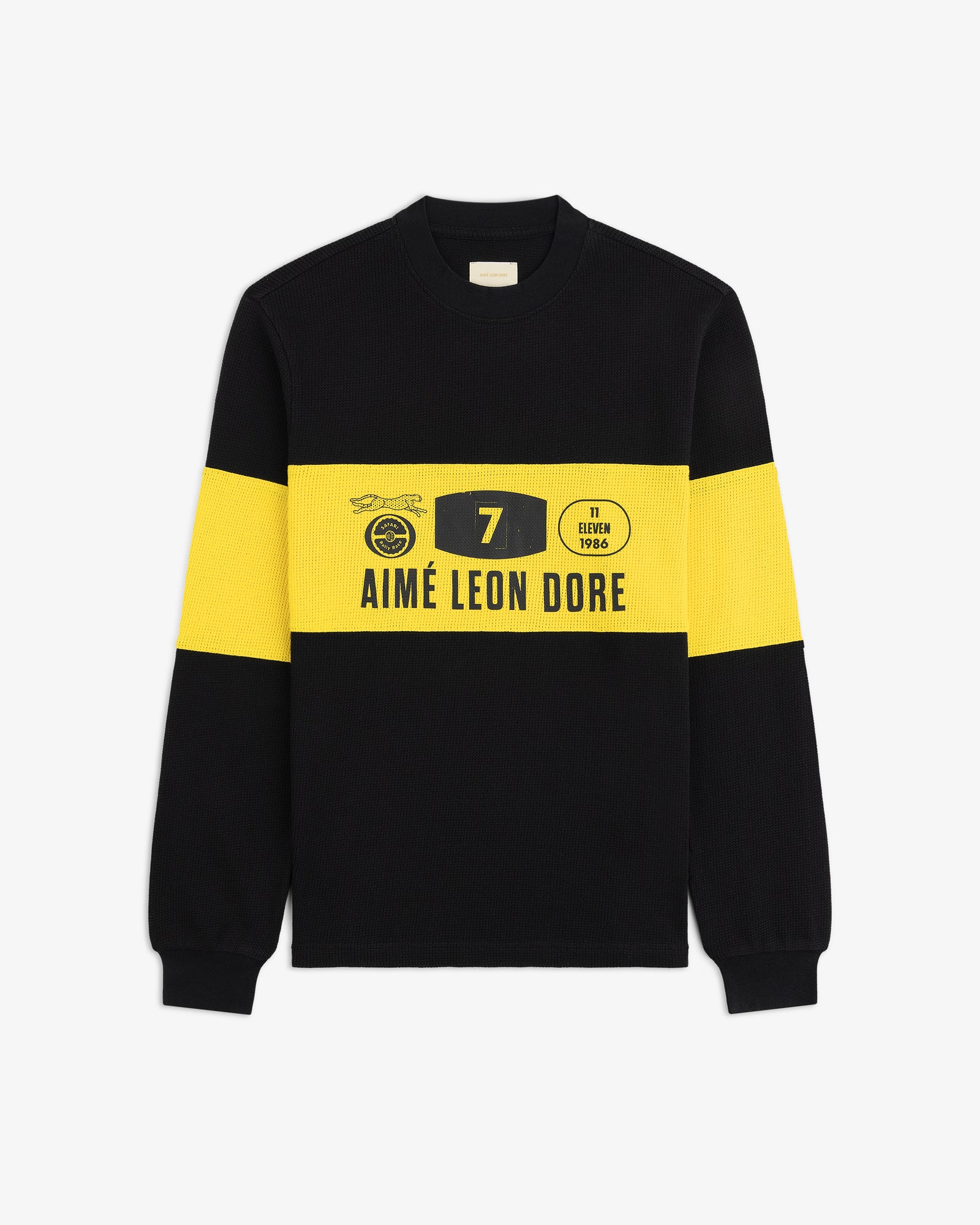 The Long-Sleeve Rally Tee is black with bold yellow bands and Aimé Leon Dore logo and graphics on the front.